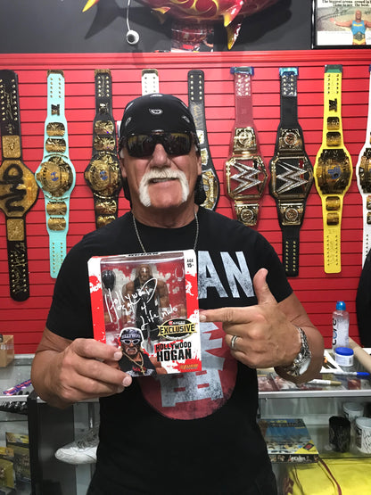 Hulk Hogan holding a Tribal Hollywood Hogan Ringside Collectibles Action Figure after he signed it