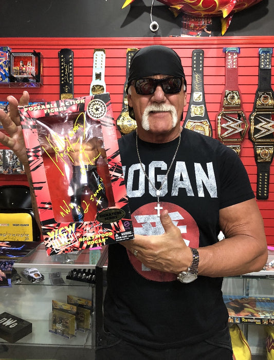 Hulk Hogan holding the Hollywood Hogan Action Figure after signing it